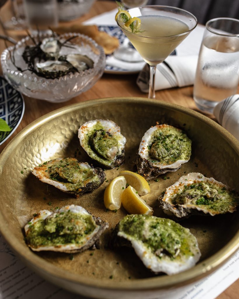 Pearl & Horn Broiled Oysters Table set with oysters and drinks