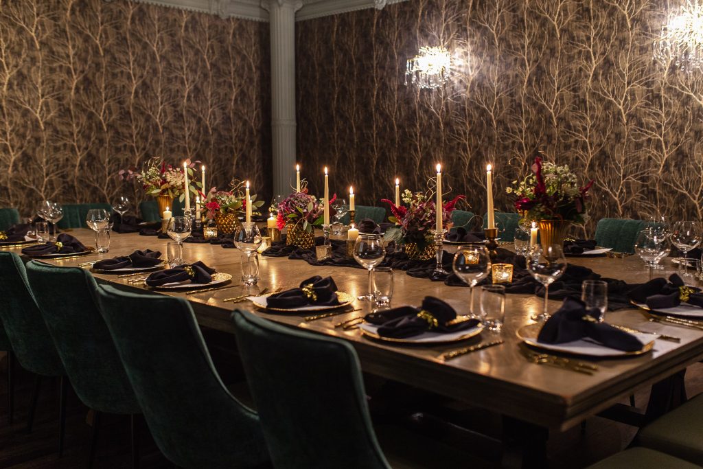 Private dining room with one large decorated table, and place settings for guests