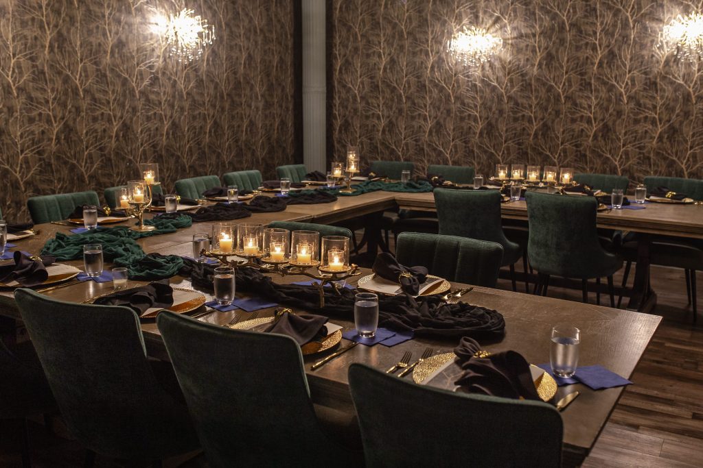 Private dining room with a U-shaped table configuration, and place settings for guests