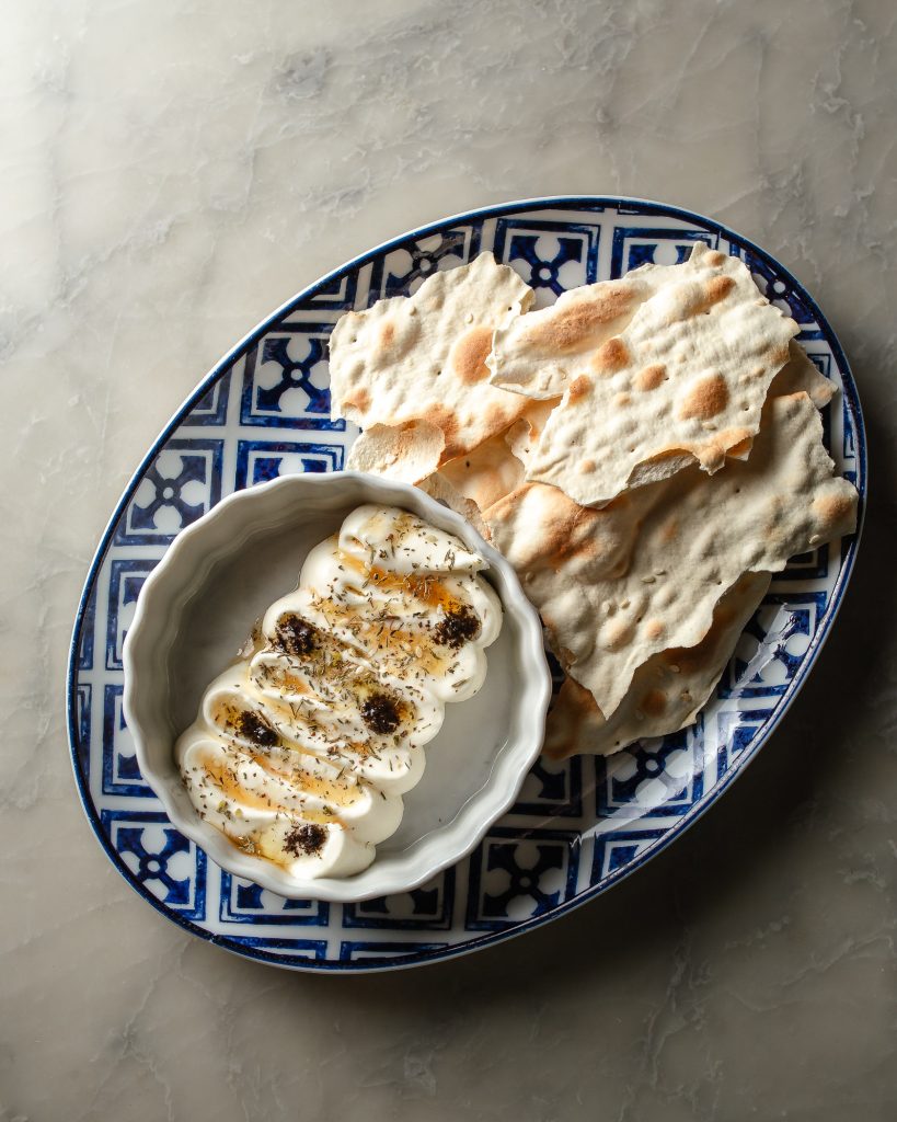 Whipped Feta in a dish with a side of lavhosh crackers